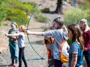 Children take turns at archery practice